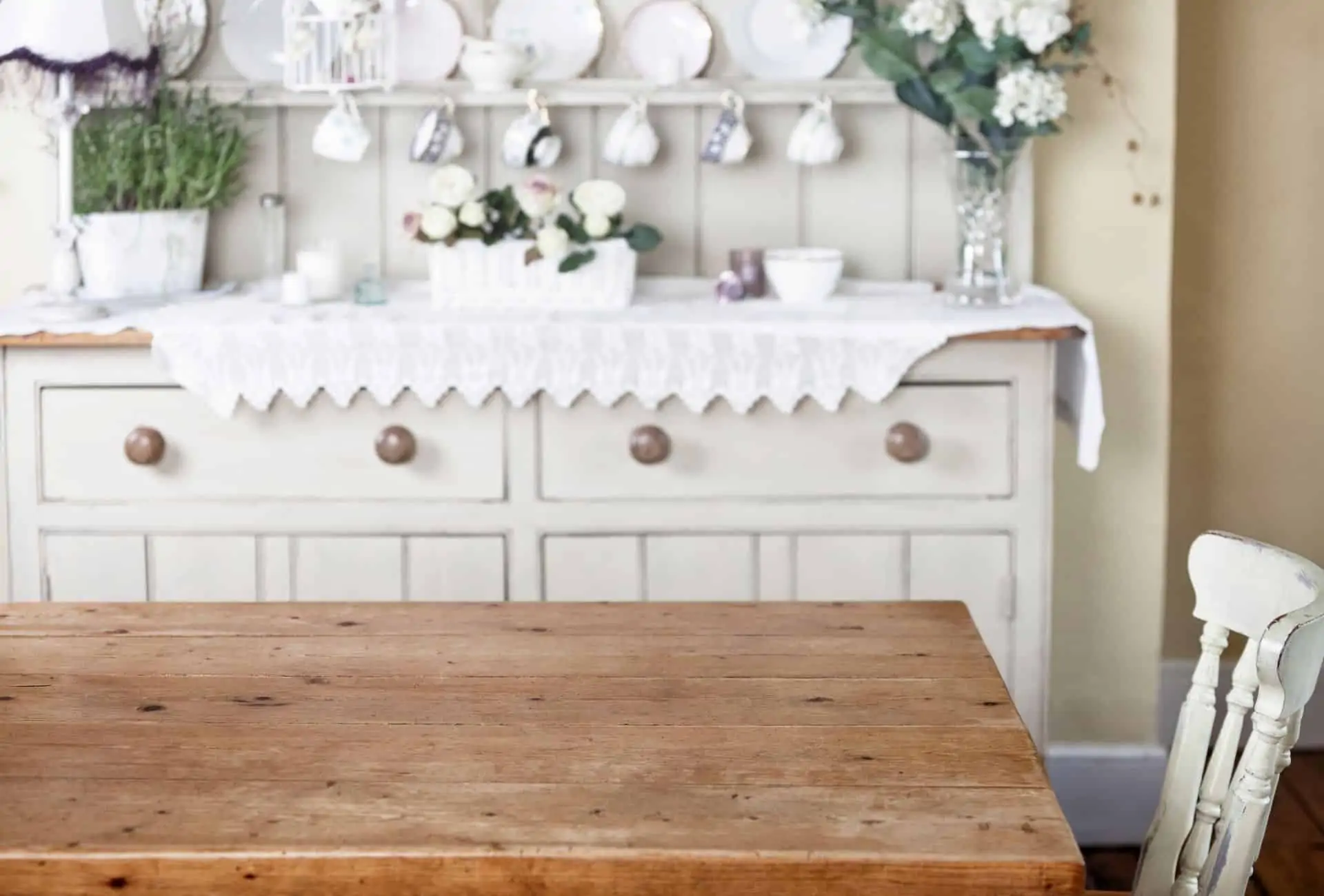 White cottagecore kitchen with vintage ceramics on display.