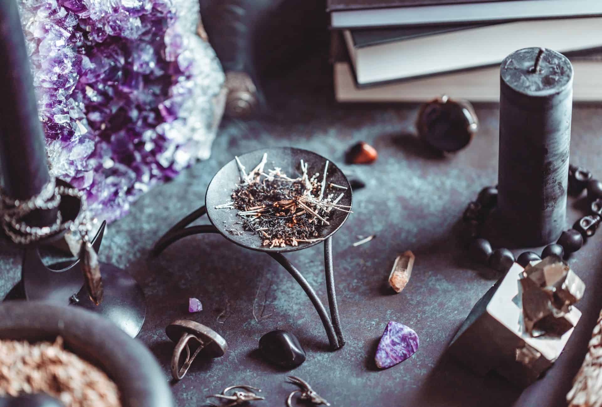 Witchy table with burned herbs in the middle.